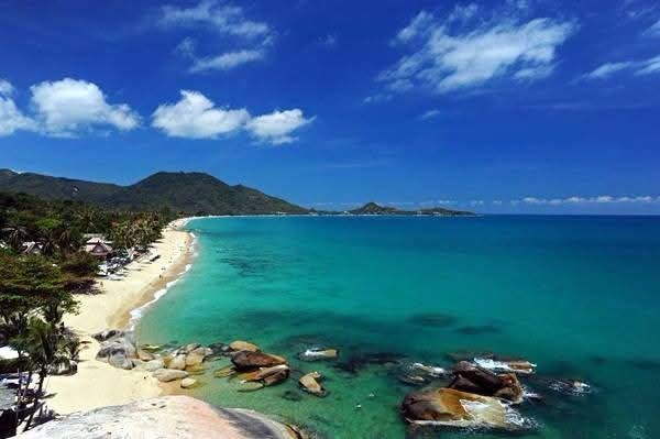 Lamai Beach, Koh Samui — wide sandy beach with clear blue water, shaded sun loungers and green hillside in the background Lamai Beach, Koh Samui — wide sandy beach with clear blue water, shaded sun loungers and green hillside in the background